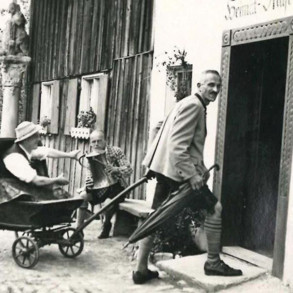 Die Gründer des Heimatmuseums Sonthofen - Andreas Bechteler (links im Wagen), Hermann Meggle (rechts) und August Schraudolph beim Einzug in das neu eröffnete Heimatmuseum (Bildunterschrift im Album: Es ist vollendet).
t
Datierung: 1930?

Besonderheit: Stempel auf Rückseite: Heimhuber Hofphotogr. Sonthofen-Oberstdorf i. bay. Allgäu. 
Aus Fotoalbum 9