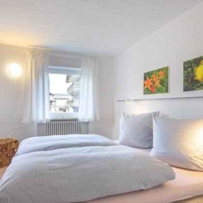 helles-schlafzimmer-mit-gemuetlichem-doppelbett-1240x700